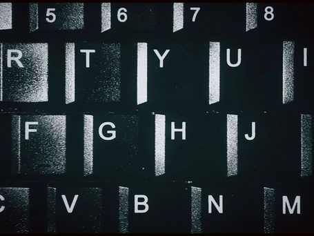 A closeup of black keys with white letters on a computer keyboard