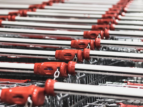 An abstract photo of shopping cart handles in rows with the red handlebars lined up.