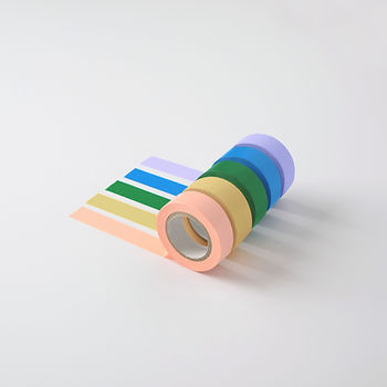 Five colorful rolls of masking tape with tails of tape stuck to a white surface.  This post is about removing sticky substances, or saying goodbye to goo.