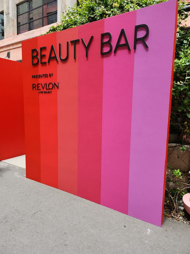 Beauty Bar presented by Revlon wall striped with pinks and reds at the Popsugar activation at the Row in DTLA for Proud Robinson.