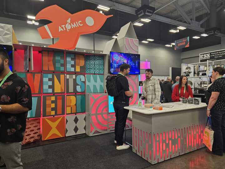 Atomic Booth with colorful graphics that say "Keep Events Weird" at Catersource 2024 at the Austin Convention Center