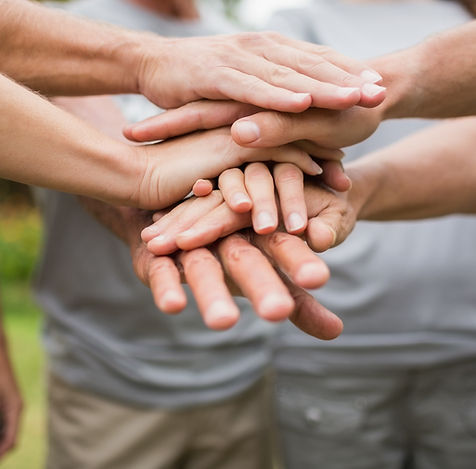 A tower of hands sandwiched on top of one another in unity.