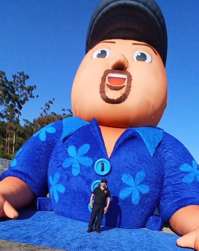 One of PopUP CleanUP's cleaners standing in front of a giant blow up doll of Gabriel "Fluffy" Iglesias at Dodger Stadium where Red Rock Entertainment held Netflix is a Joke.