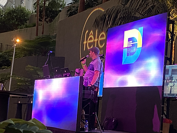 A DJ at a FêteLA event at SoFi stadium playing music.