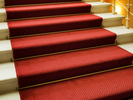 A red carpet going up a flight of stairs.