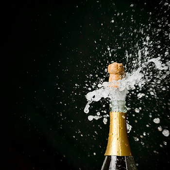 A bottle of champagne exploding open.