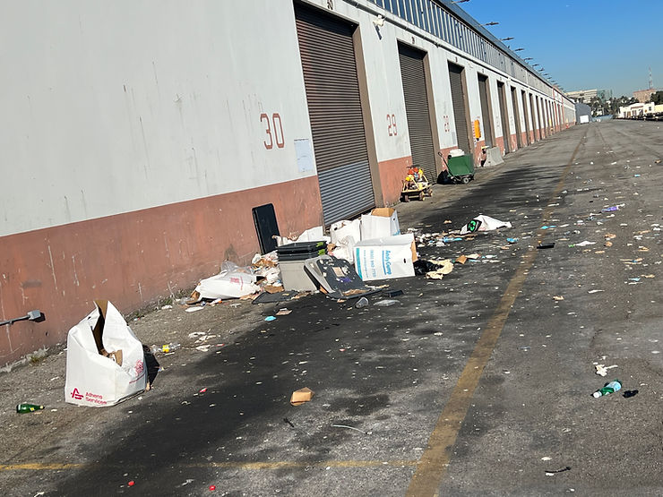 Trash smashed all over the ground as if the dumpster had been dived into and spread everywhere.  The dumpsters have been removed and litter is scattered all over the asphalt.