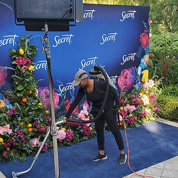 PopUP CleanUP cleaner vacuuming the blue carpet in front of a floral display at the Secret Deodorant branding activation at a private estate for P&G.