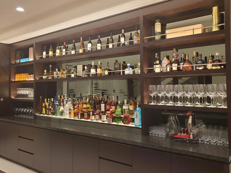 A wall of liquor and glasses at a private home for a branding event