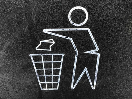 A chalk icon of a person throwing a piece of paper away in a waste bin.