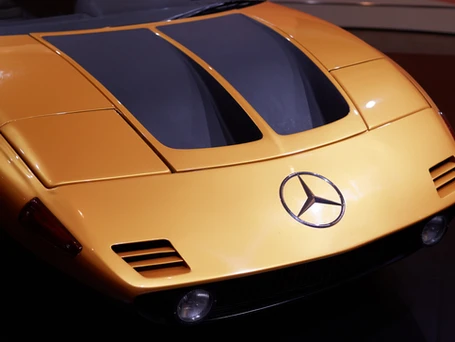 The hood of a high tech designed orange Mercedes sports car.