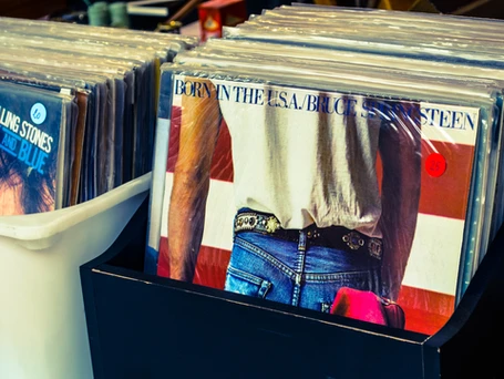 A bin of vinyl record albums with Bruce Springsteen's BORN IN THE USA at the front of the bin.