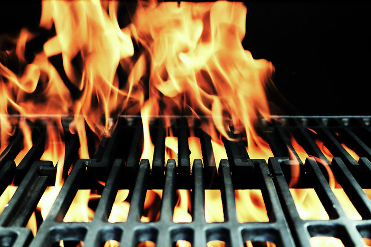 Orange flames flicking up from a black grill for our post about how to clean your outdoor grill.