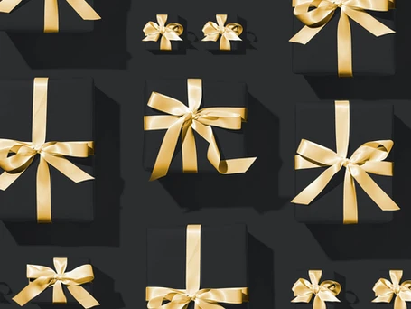 Black wrapping paper and gold ribbon wrapped gift boxes.