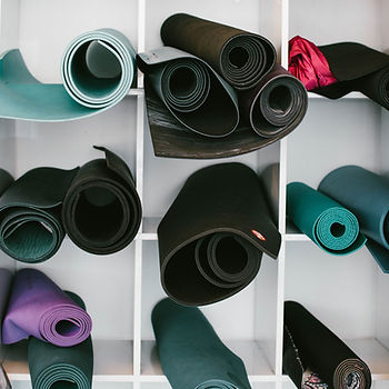 Cubbyholes with rolled up yoga mats.