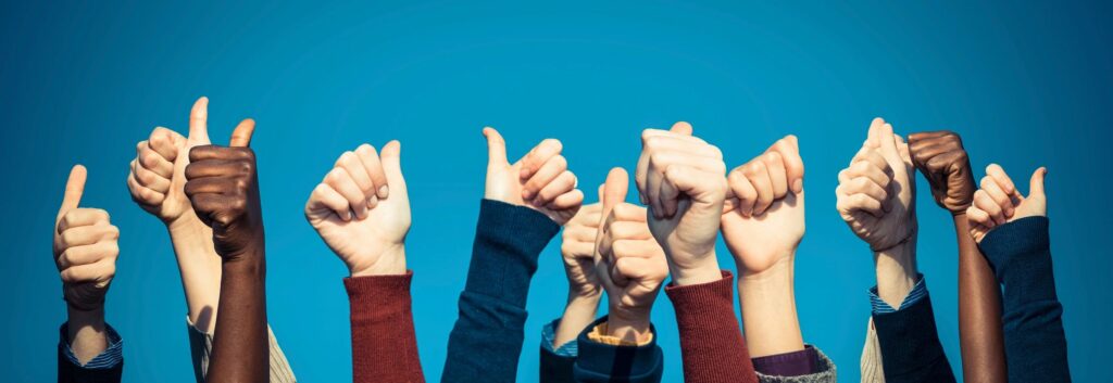 Hands raised in protest against a blue sky backdrop