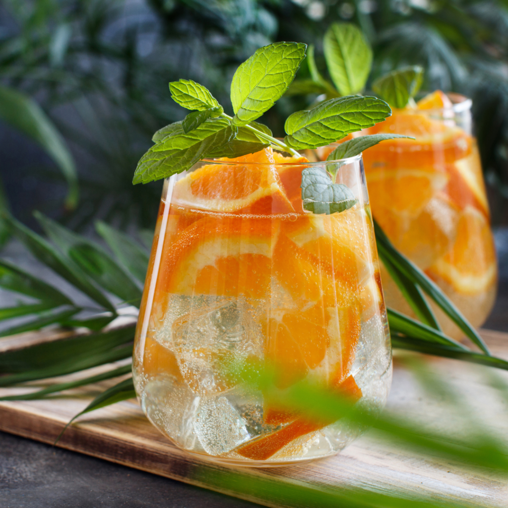 Orange slices in a fizzy Mocktail drink with green mint garnish.